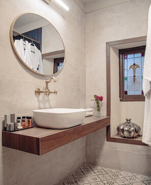 A bathroom with a round mirror, a white sink, and a wooden countertop. - Villa Tehila (Rosh Pinna)
