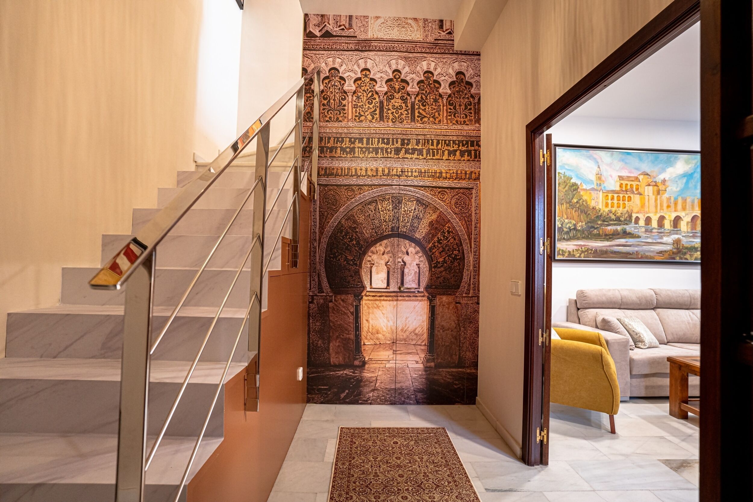 A staircase with a patterned wall, a sofa, and a painting of a building.