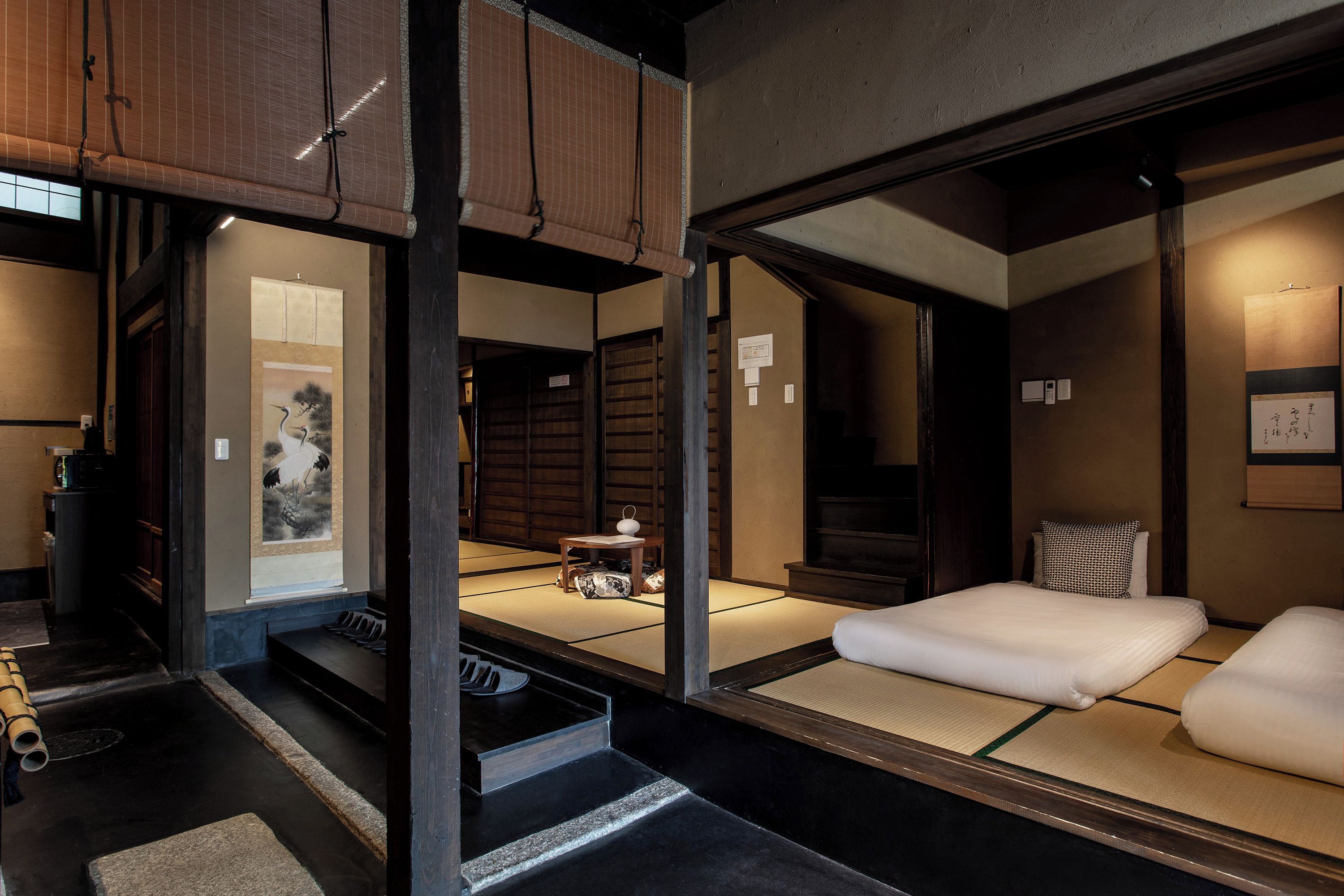 A traditional Japanese room with tatami flooring, a futon bed, and a shoji screen door.