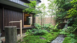 A traditional Japanese garden with a stone pathway, moss, and ferns. - Mitsuda Kamigyo (Kyoto)