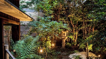 Jardí japonès tradicional amb un fanal de pedra, bambú i un camí.