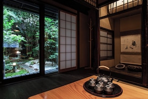 A traditional Japanese room with tatami flooring, a shoji screen, and a view of a garden. - Mitsuda Kamigyo (Kyoto)