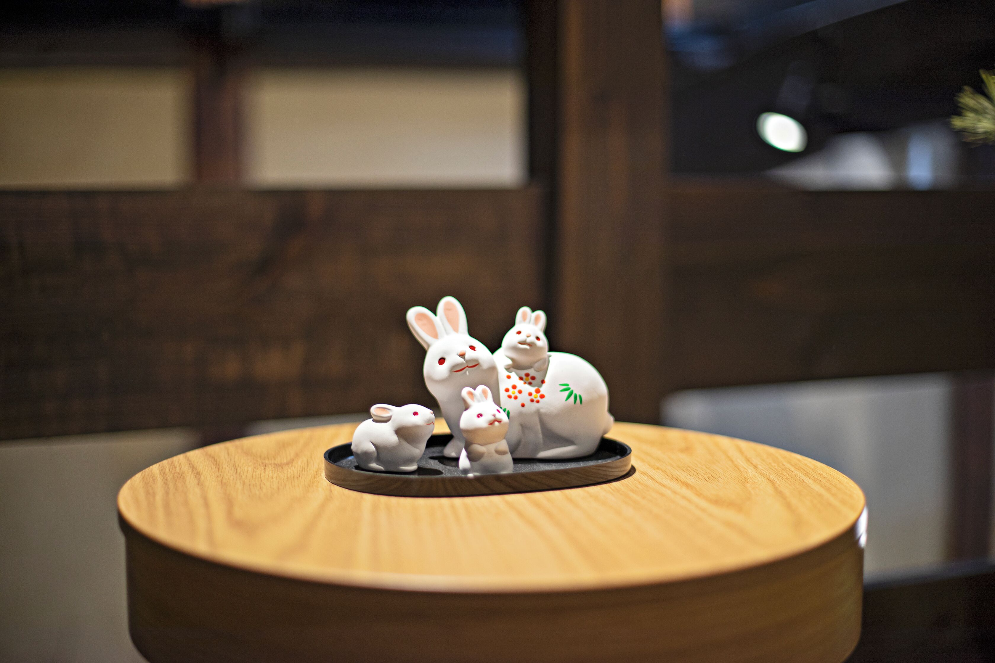 A wooden table with a ceramic rabbit figurine set on top.