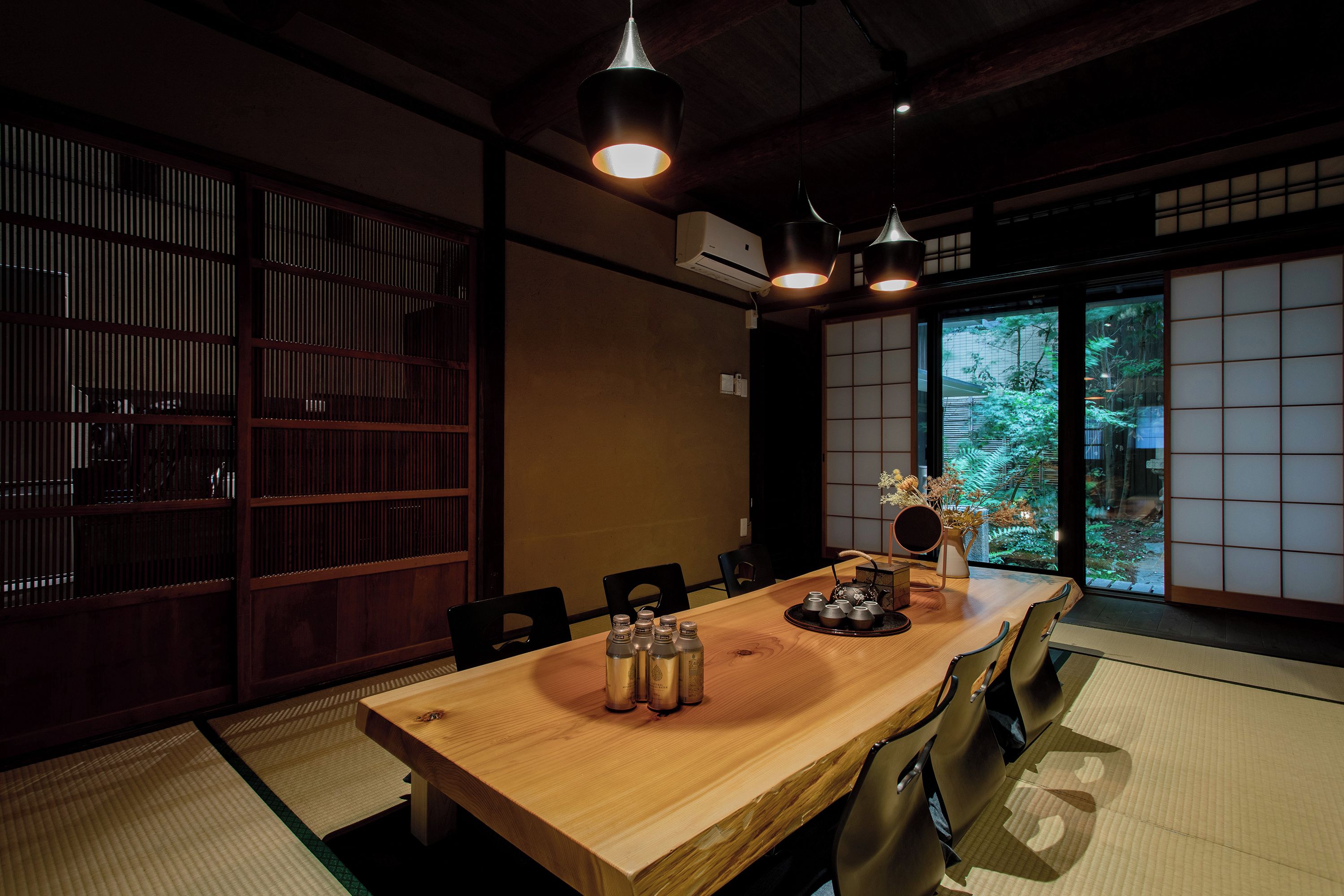 Una habitación tradicional japonesa con suelo de tatami, una mesa de madera baja y puertas correderas shoji.