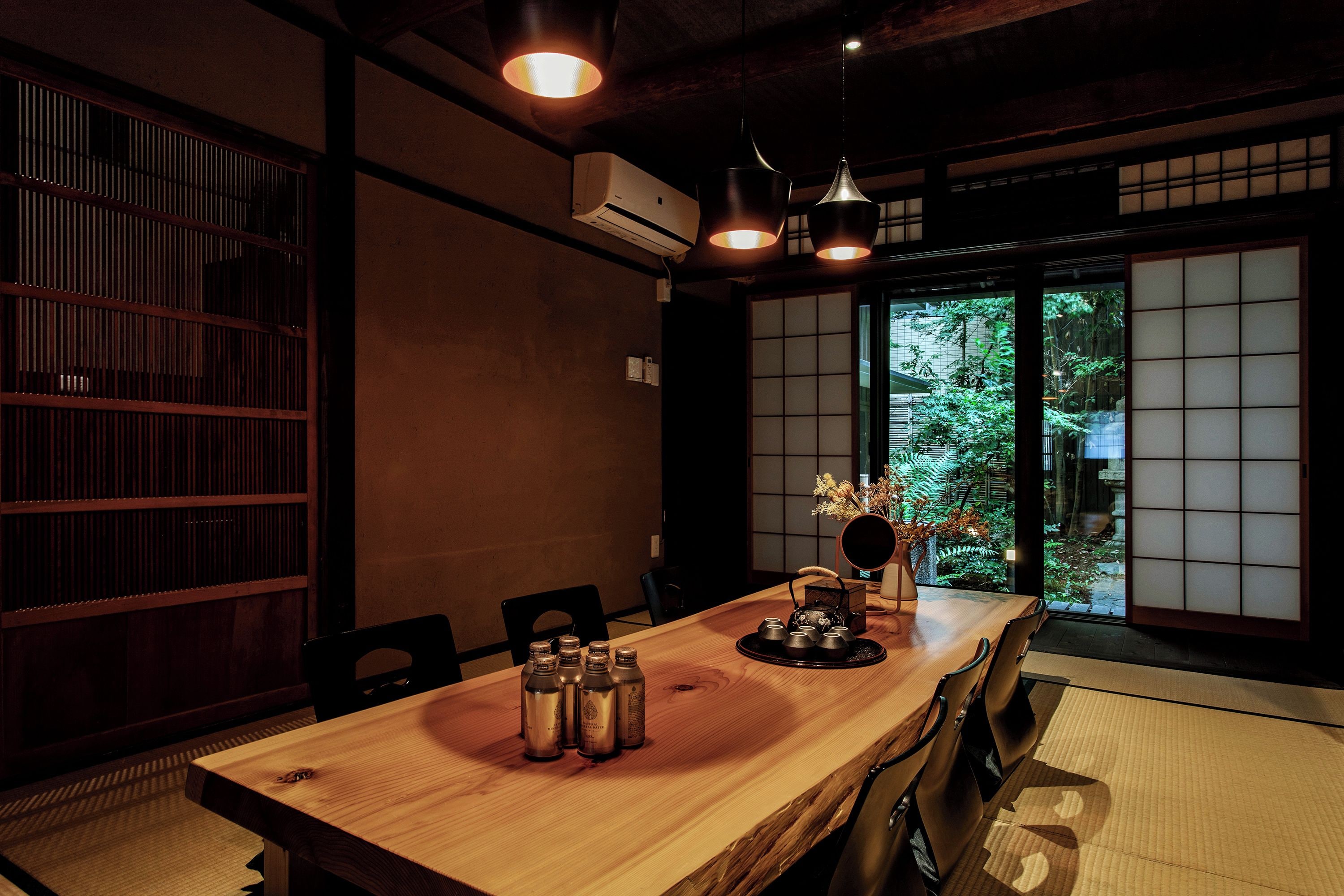 A traditional Japanese room with tatami flooring, a low table with tea set, and sliding doors.