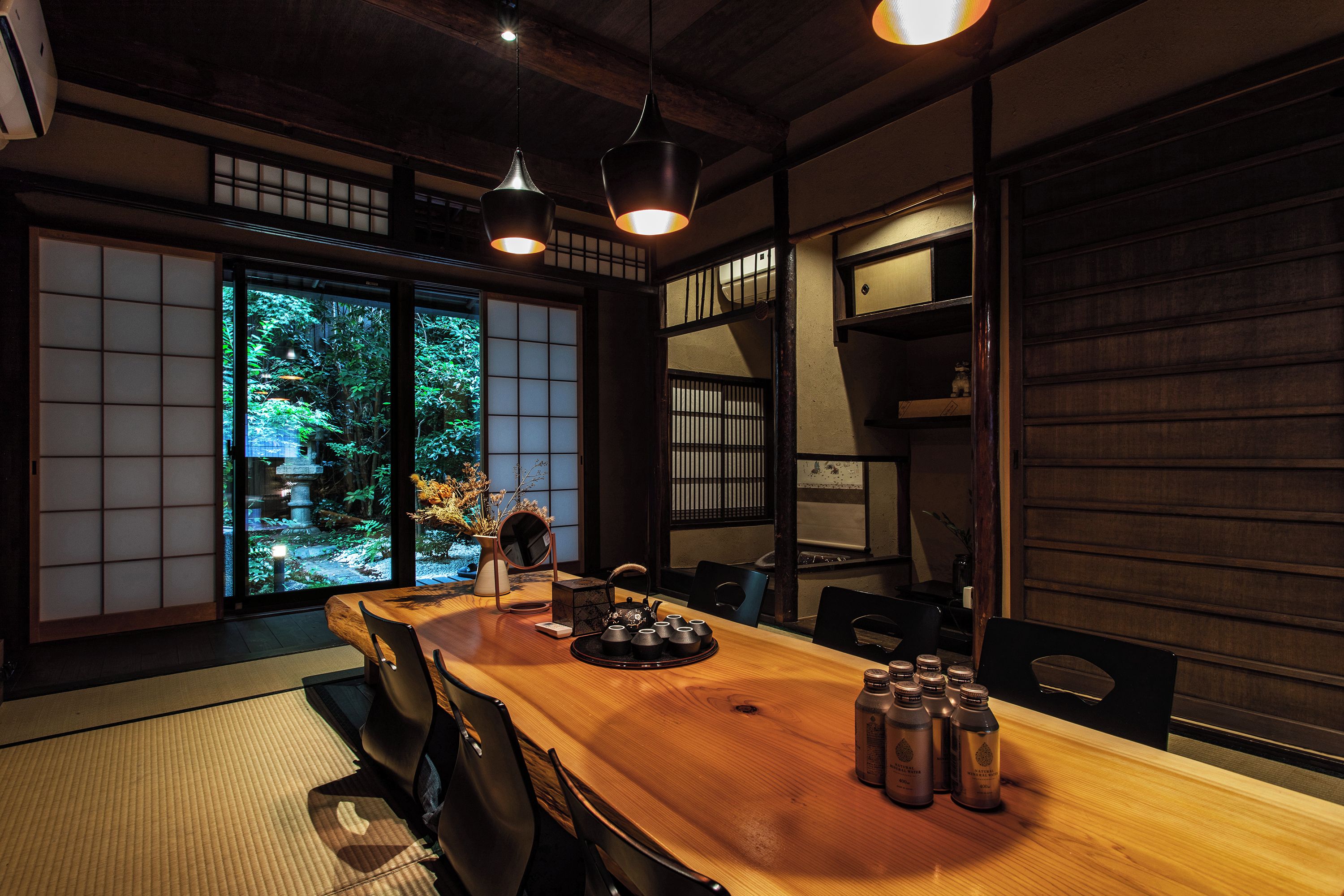 Habitació japonesa tradicional amb fons de tatami, una taula de fusta i portes corredisses.