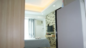 Une chambre moderne avec un lit, une télévision et une étagère murale décorée de fleurs.