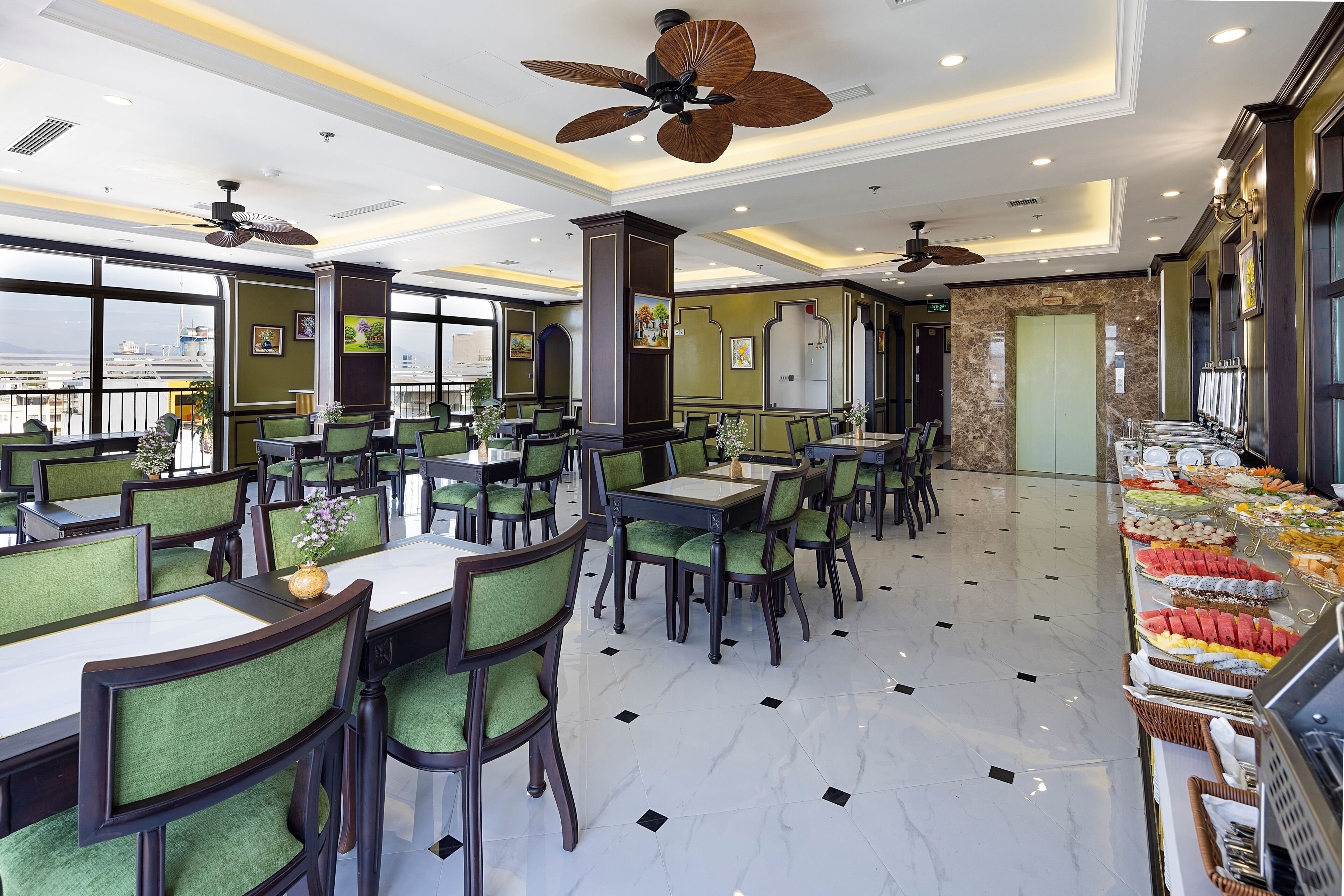 A spacious restaurant with high ceilings, multiple ceiling fans, and a buffet area with various food items.