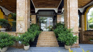 A hotel entrance with a stone staircase, potted plants, and a sign indicating a spa. - Charming Beauty Hotel (Da Nang)