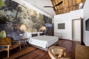 A bedroom with a large bed, two bedside tables, a ceiling fan, a mural, and a door. - Nusantara Loft Rote by Alfred in Bali (Canggu)