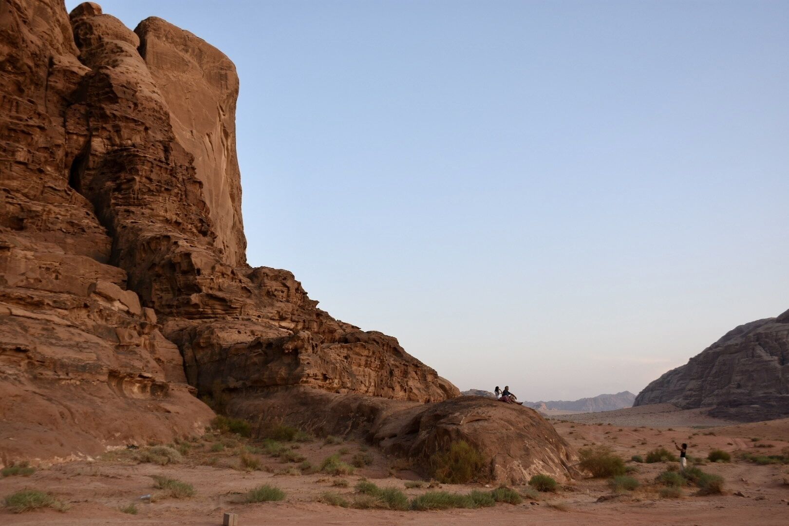 A desert landscape with rocky formations and a clear sky.