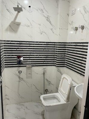 Habitación doble Deluxe | Baño | Regadera, pantuflas, toallas, jabón 
