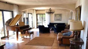 A spacious living room with a grand piano, a sofa set, and a chandelier. - Superb Villa with swimming pool in Nice (Nice)