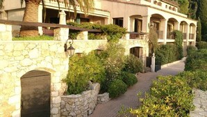 A multi-story building with a stone facade, arched balconies, and lush greenery. - Superb Villa with swimming pool in Nice (Nice)