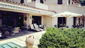 A villa with a pool, outdoor seating, and a large umbrella. - Superb Villa with swimming pool in Nice (Nice)