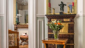 A room with a wooden table, a mirror, a statue, and a vase with flowers. - New Paris Centre Historic Marrais Montorgueil Chic Suite Familiale 2 Bedrooms (Paris)