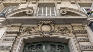A building facade with ornate architectural details, including a decorative archway and a green door with intricate metalwork. - New Paris Centre Historic Marrais Montorgueil Chic Suite Familiale 2 Bedrooms (Paris)