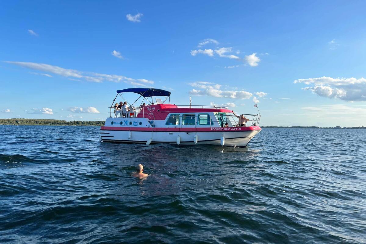 Ein Schiff mit überdachter Deck und Passagieren.