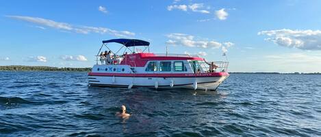 A boat with a covered deck and passengers.