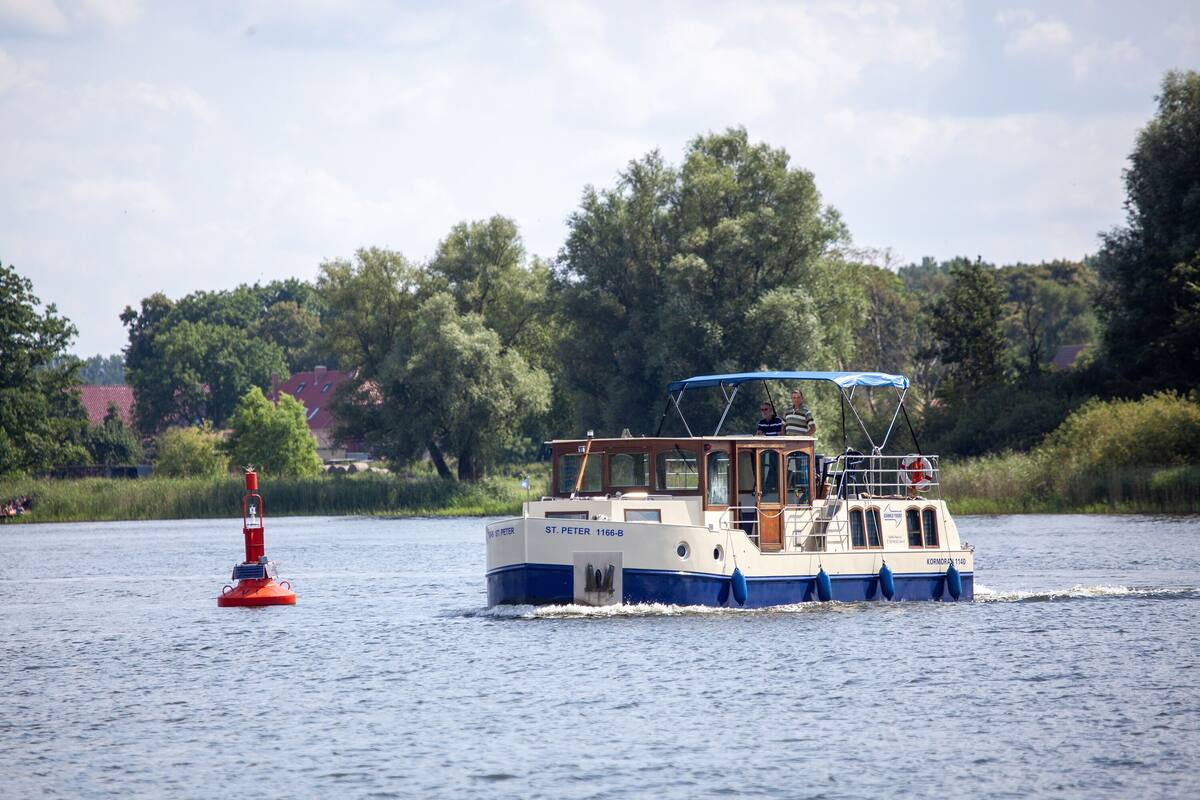 Ein Boot mit dem Namen ST. PETER 1166-B auf dem Wasser, in der Nähe ein roter Boje.