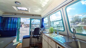 Una cocina compacta con un lavabo, una silla y una pequeña mesa.