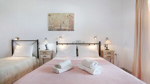 Une chambre d’hôtel avec deux lits, un grand tableau au mur et des lampes de chevet.