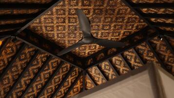 A ceiling fan in a room with a patterned wall.