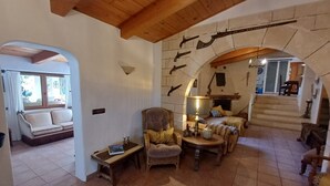 Ein gemütliches Wohnzimmer mit Kamin, einer Couch, einem Sessel und einem Tisch.