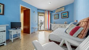Une chambre à coucher avec un lit, une télévision, une petite table et une armoire.
