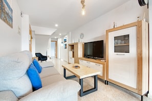 A modern living room with a sofa, a coffee table, a TV, and a cabinet.