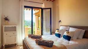 A bedroom with a bed, a nightstand, a window with a view, and a door leading to an outdoor area. - Holiday Home 'La Bastide Des Oliviers' with Mountain View, Wi-Fi and Air Conditioning (Auriol)