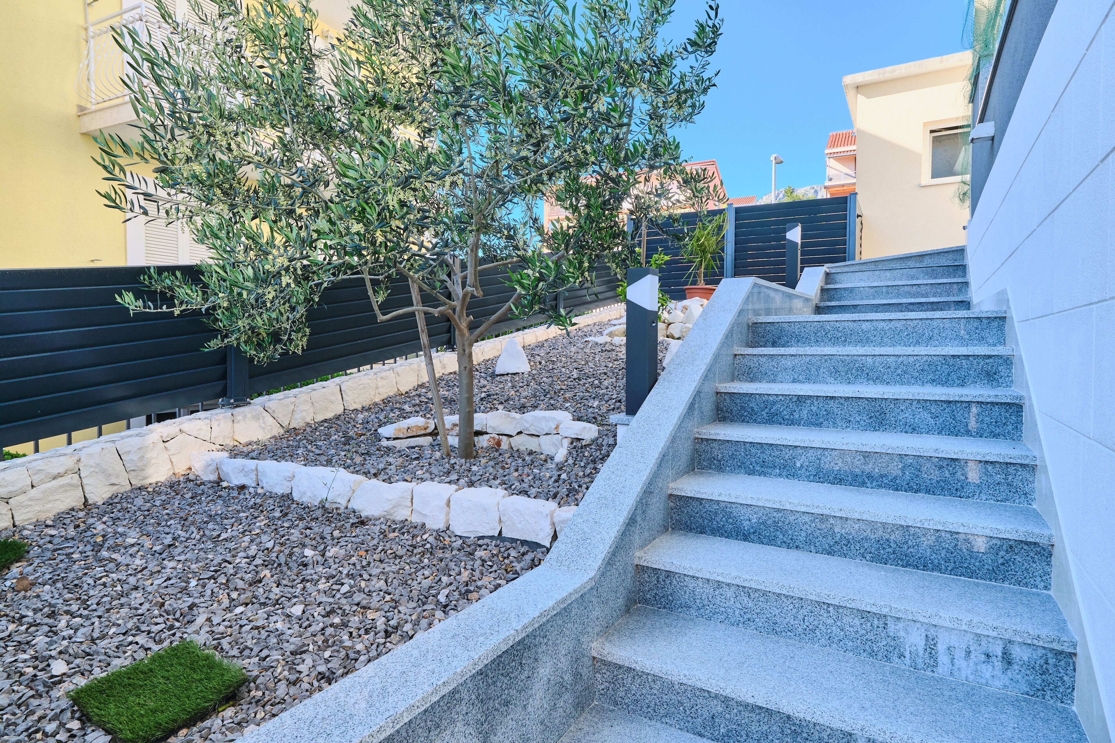 A modern building with a stone staircase leading to a flat roof.