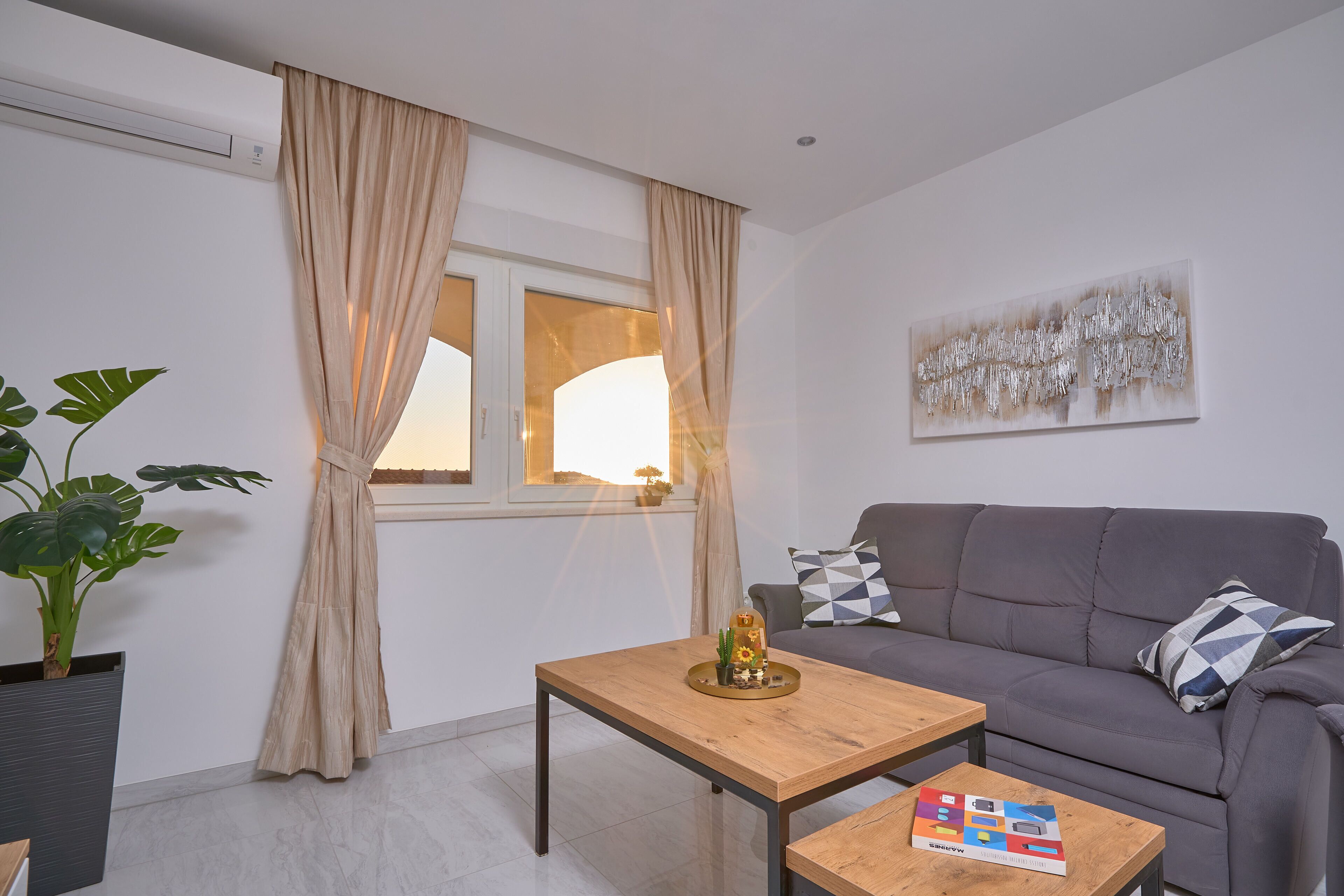 Una sala de estar moderna con un sofá, una mesa de centro y una planta en maceta.