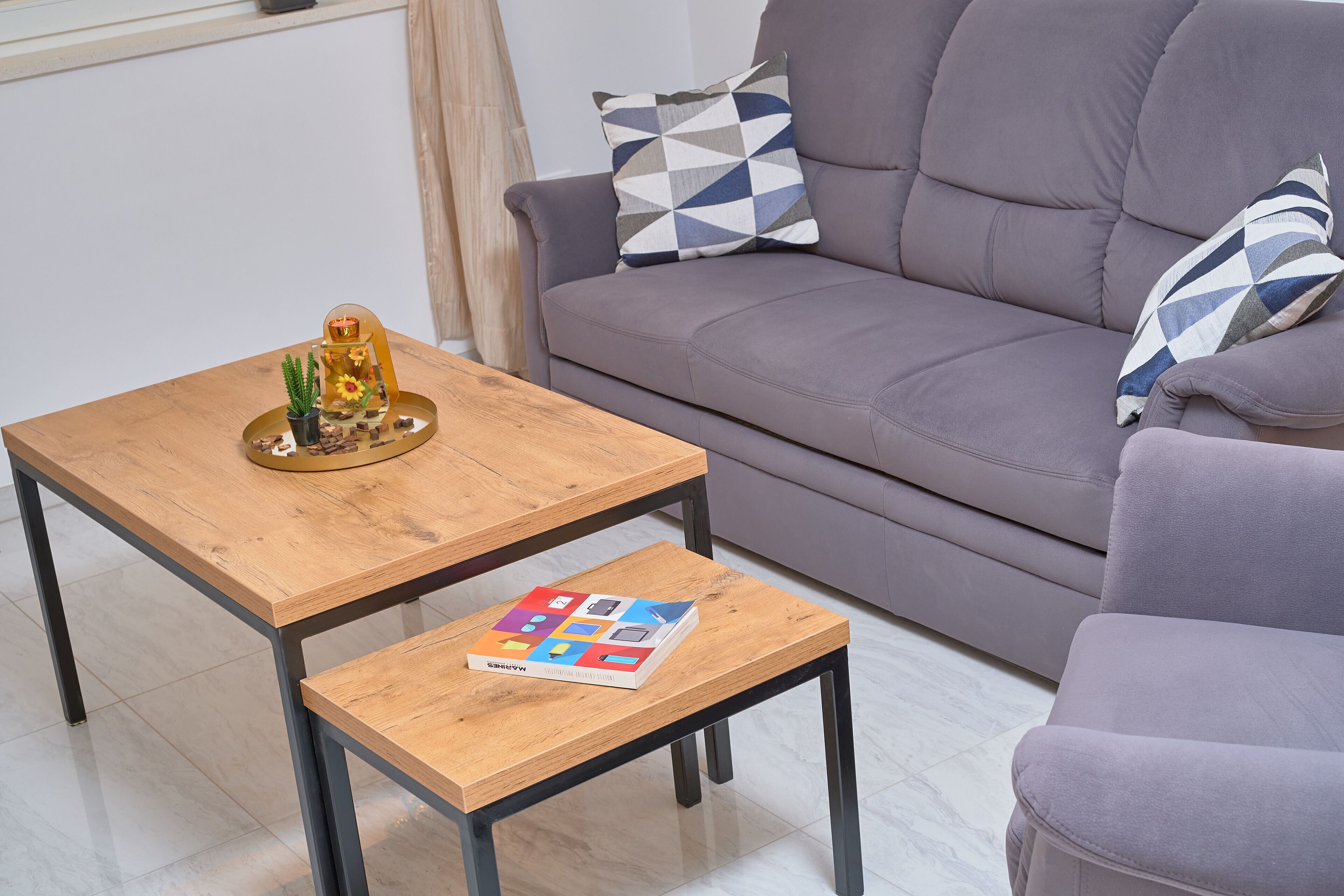 A living room with a grey sofa, a wooden coffee table, and a small side table.