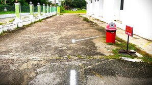Un camino conduce a un edificio con un cartel que indica 'Green Mango Hotel' y un letrero de 'No Estacionar'.