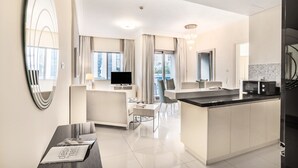 Una habitación de hotel moderna con zona de estar, comedor y cocina.