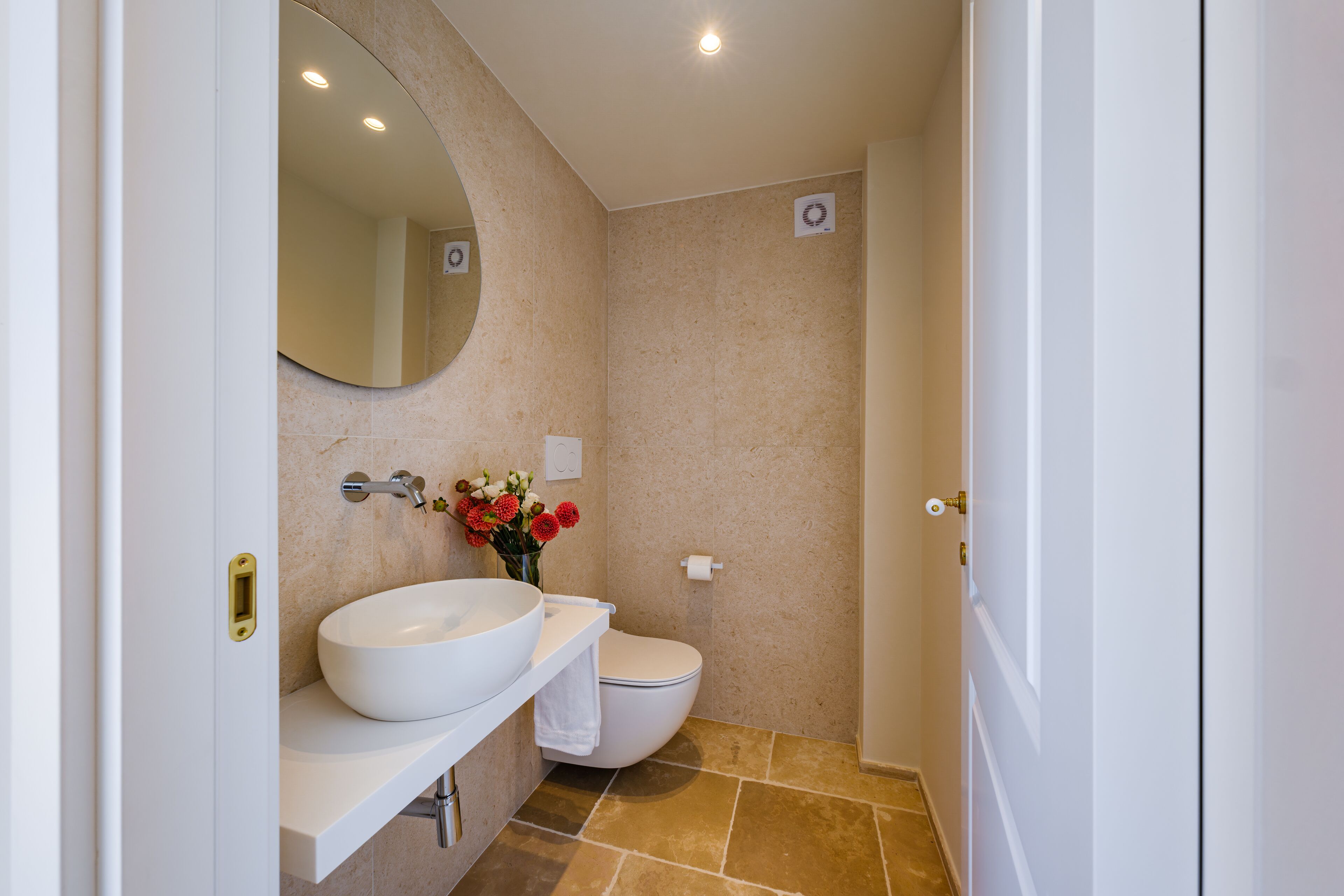 A bathroom with a white sink, a toilet, and a mirror.