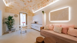 A modern living room with a sofa, coffee table, and dining area. - Palazzo Clemente (Monopoli)
