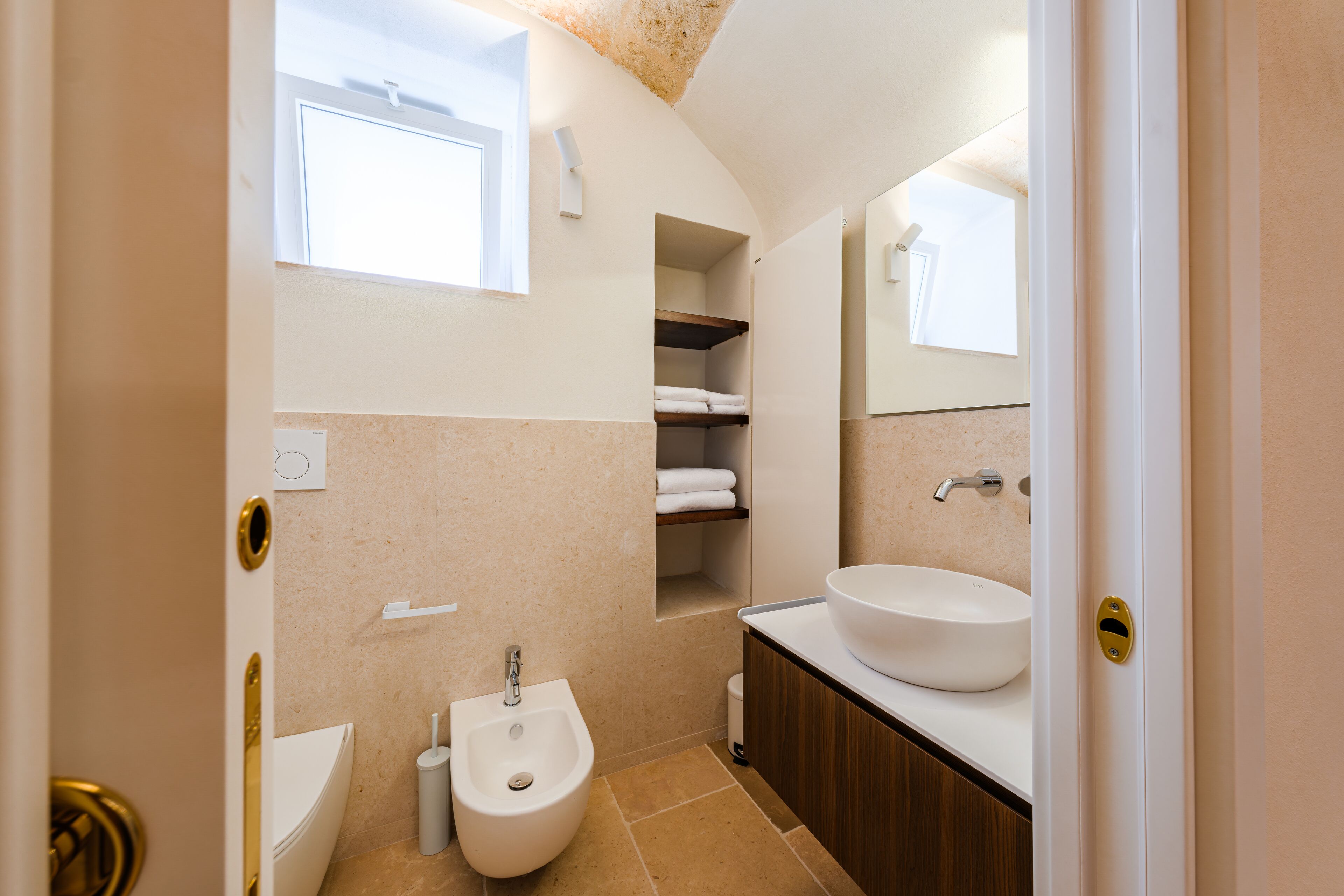 Une salle de bain équipée d’un bidet, d’un lavabo et d’un miroir.
