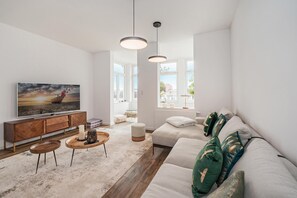 Un salon moderne avec un canapé, une table basse et un téléviseur.