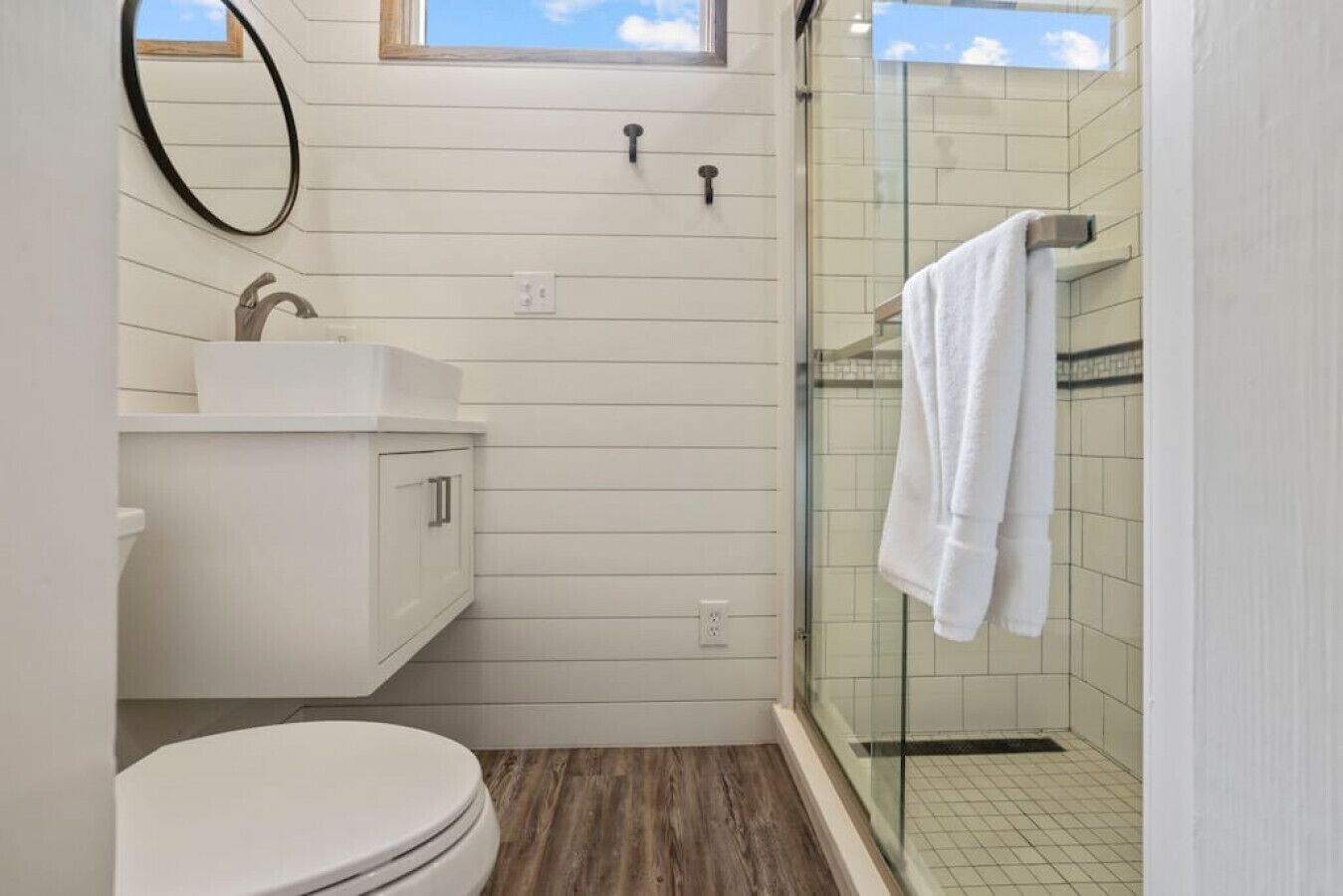 A compact bathroom with a toilet, sink, and shower.