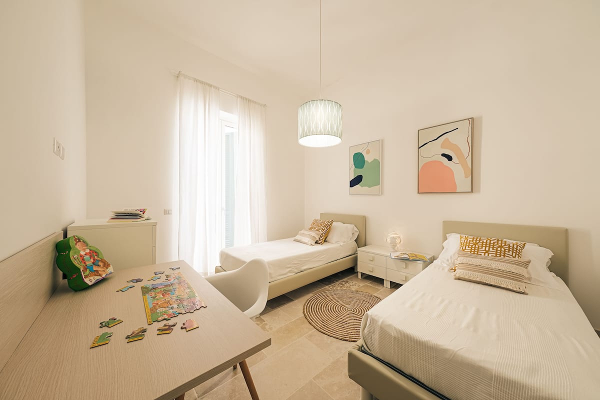 Une chambre moderne avec deux lits, un bureau et une chaise.