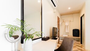 A modern bathroom with a mirror, a plant, a towel rack, and a shower area. - SJ Miracle Hotel (Hat Yai)