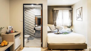 A hotel room with a bed, bedside table, and a bathroom visible through an open door. - SJ Miracle Hotel (Hat Yai)