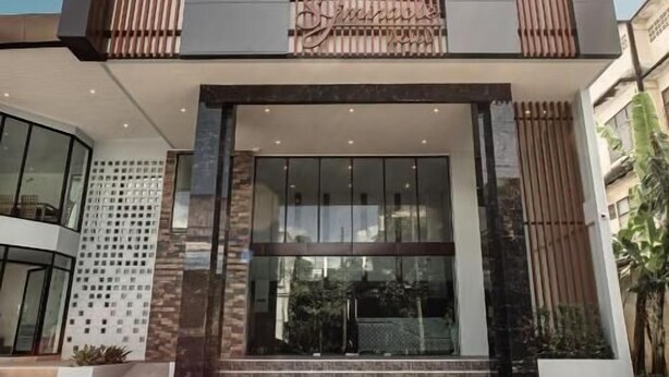 A modern building with a glass entrance and a wooden facade. - SJ Miracle Hotel (Hat Yai)
