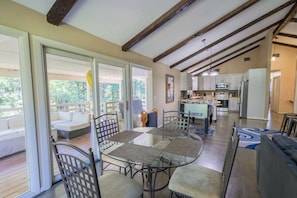 A spacious living area with a glass-top coffee table, comfortable seating, and a view of the outdoors.
