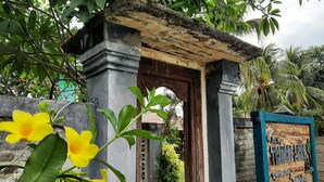 A rustic wooden gate with a signboard indicating a new restaurant and bar. - New Taman Sari Homestay (Pemenang)
