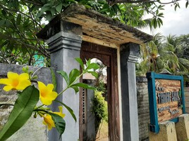 Una rústica puerta de madera con un letrero anunciando un nuevo restaurante y bar.