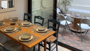 Ein Essbereich mit einem Holztisch, gedeckt für vier Personen, umgeben von Stühlen.