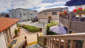 A residential area with a covered patio, a wooden fence, and a stop sign. - Driftwood Getaway! South Mission Beach (San Diego)